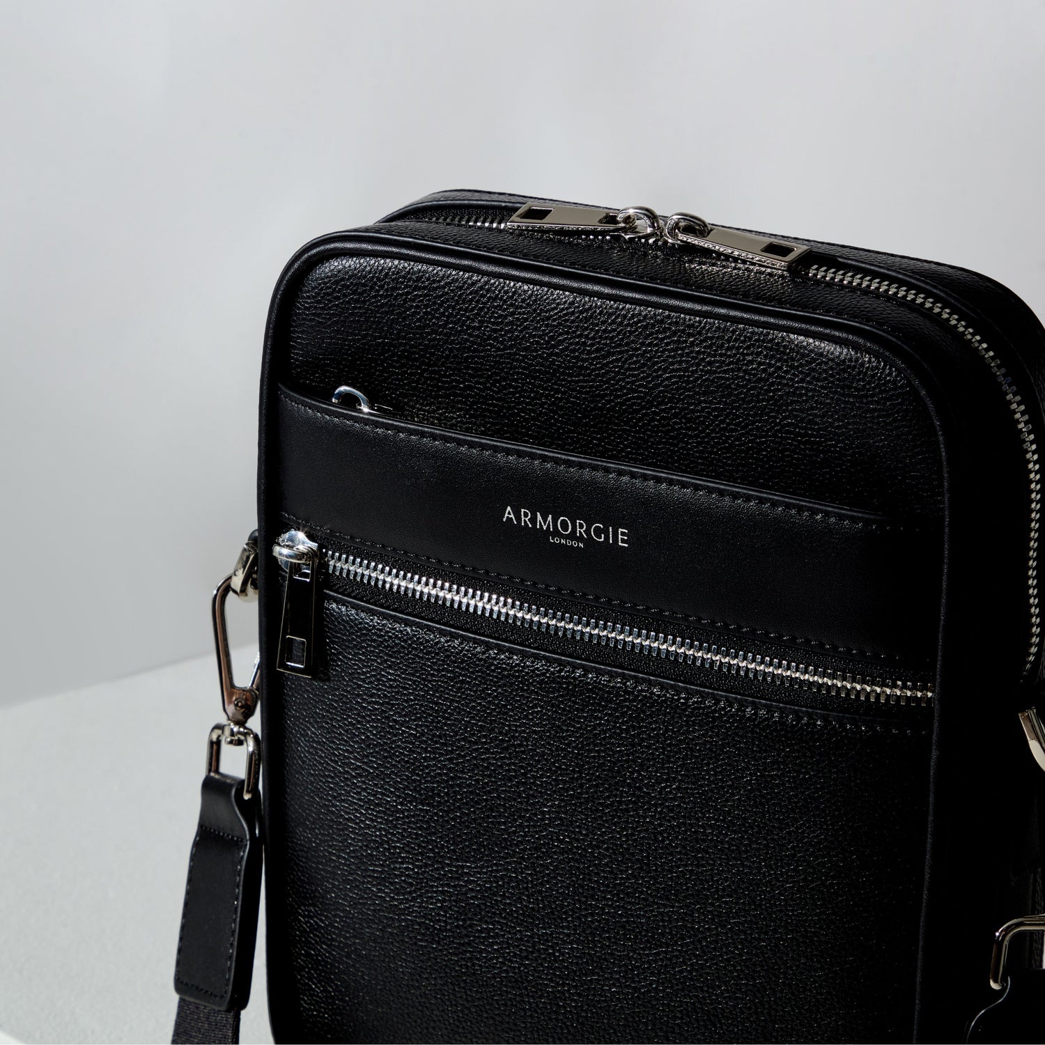 An image of a black pebble leather crossbody bag with smooth leather trims and silver hardware